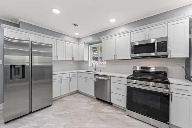 a kitchen with stainless steel appliances granite countertop a stove top oven microwave and cabinets