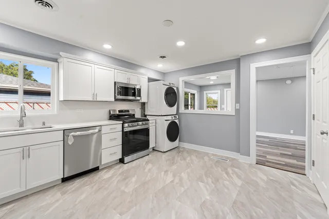 a kitchen with granite countertop a sink and steel appliances