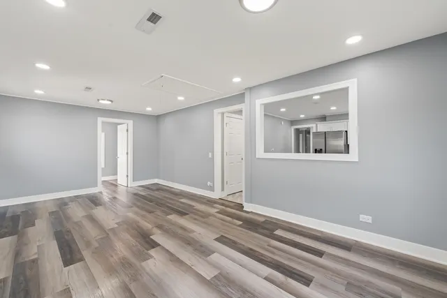 a view of empty room with wooden floor