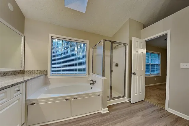a bathroom with a tub shower and sink