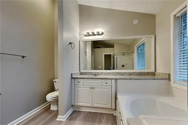 a spacious bathroom with a granite countertop sink and a mirror