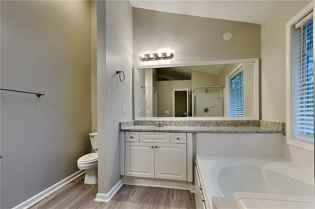 1664 Summit Pl Way Loganville, GA 30052 - Photo 13 of 23 a spacious bathroom with a granite countertop sink and a mirror