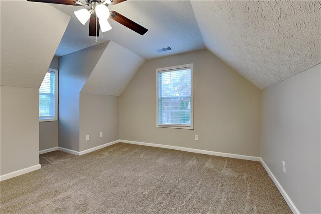 1664 Summit Pl Way Loganville, GA 30052 - Photo 18 of 23 an empty room with windows and fan