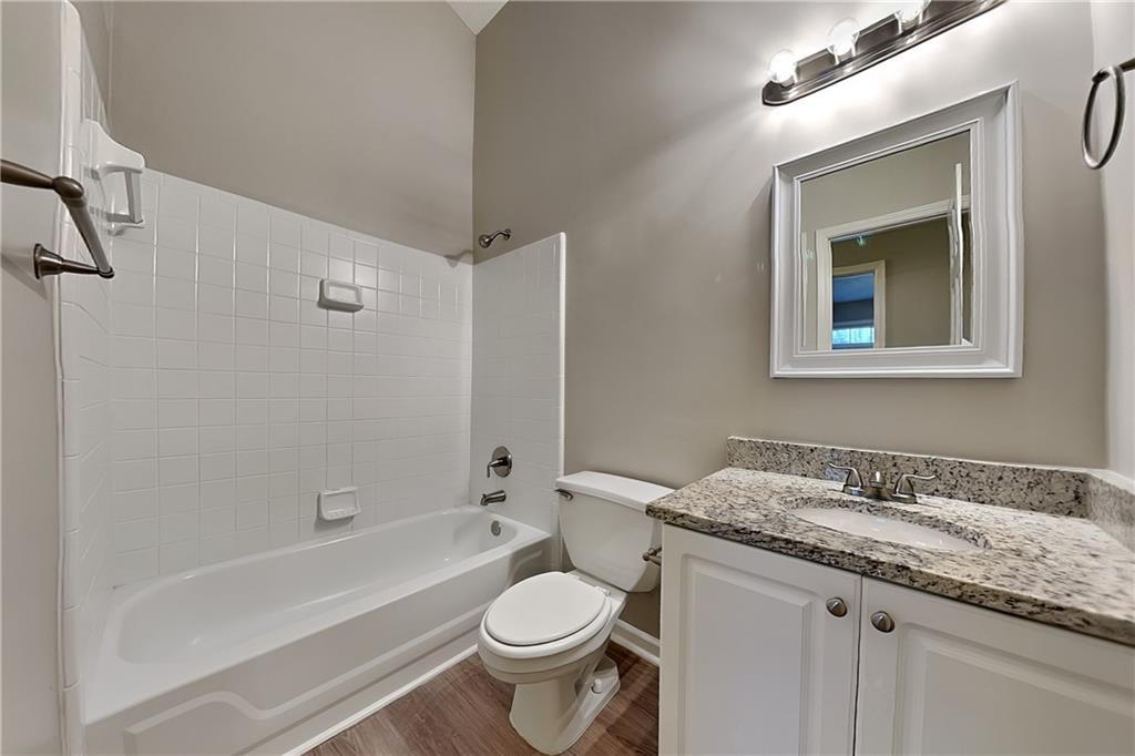 1664 Summit Pl Way Loganville, GA 30052 - Photo 20 of 23 a bathroom with a granite countertop sink toilet and shower