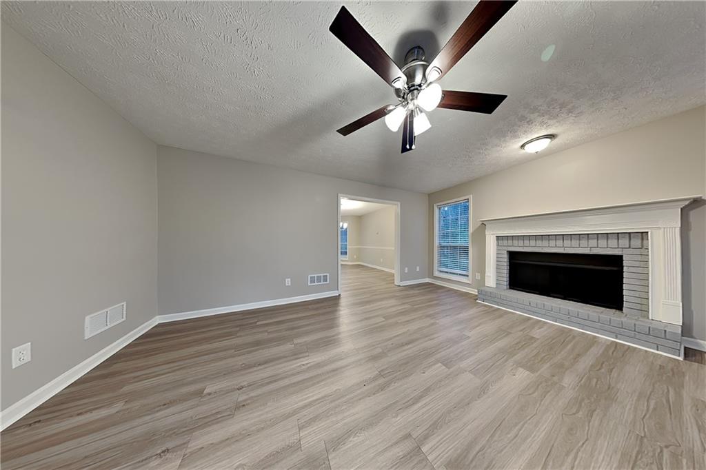 1664 Summit Pl Way Loganville, GA 30052 - Photo 2 of 23 a view of an empty room with wooden floor and a fireplace
