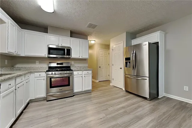 a kitchen with stainless steel appliances a refrigerator stove and microwave