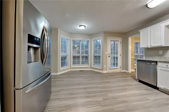 a view of a kitchen with a sink and dishwasher a refrigerator with wooden floor