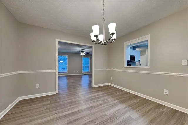 a view of a room with wooden floor and chandelier