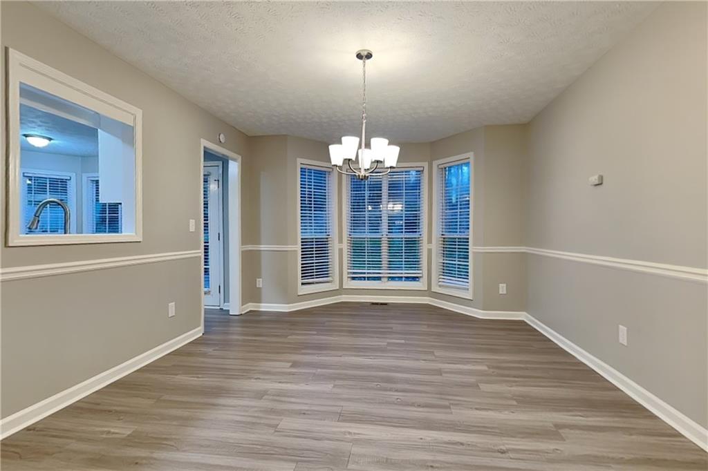 1664 Summit Pl Way Loganville, GA 30052 - Photo 8 of 23 wooden floor in an empty room with a window
