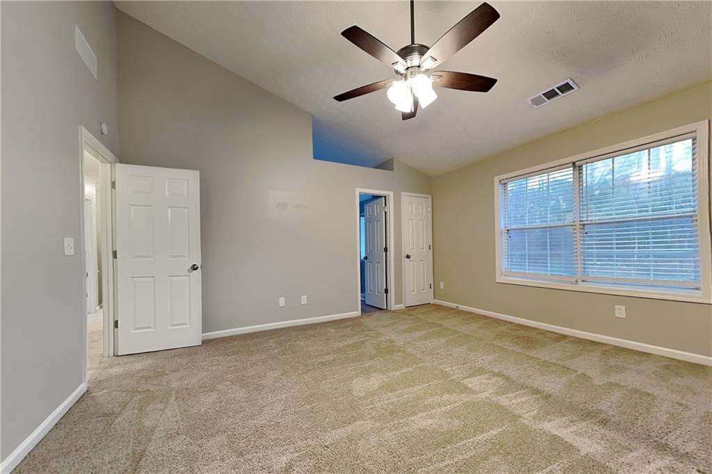 1664 Summit Pl Way Loganville, GA 30052 - Photo 9 of 23 an empty room with chandelier fan and windows
