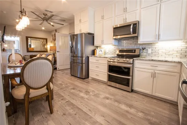 a kitchen with stainless steel appliances a stove a sink refrigerator and a microwave