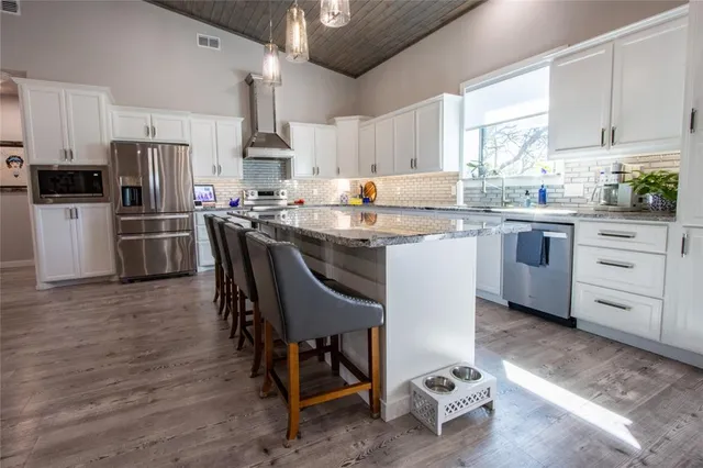 a kitchen with white cabinets and stainless steel appliances