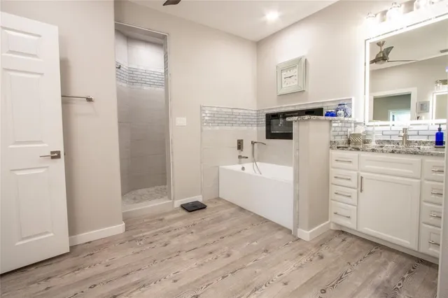 a view of a kitchen with white cabinets and wooden floor