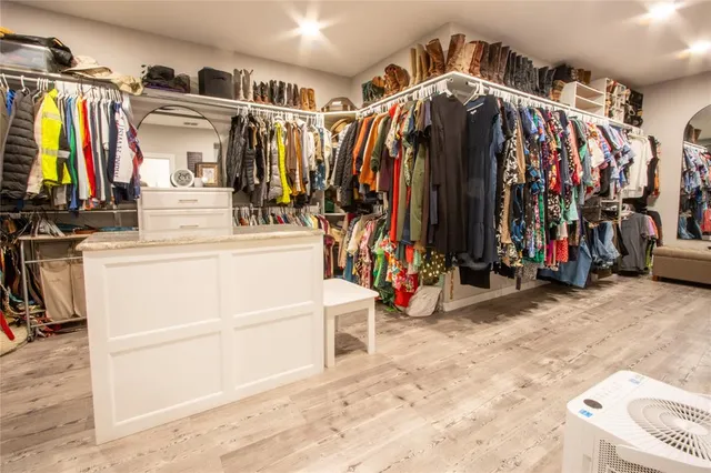 a view of walk in closet with clothes and shoes