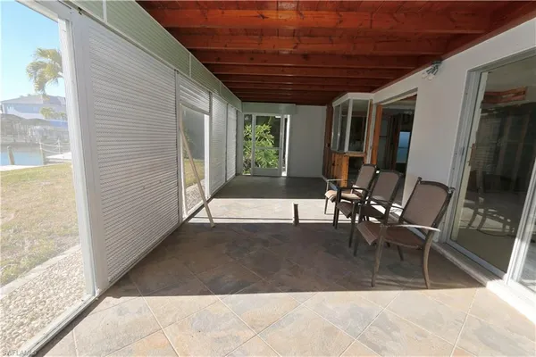 a view of a patio with table and chairs with wooden floor and plants