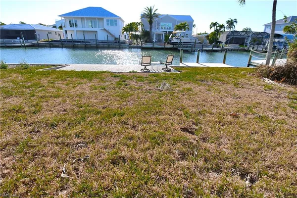 a front view of a house with a yard and potted plants