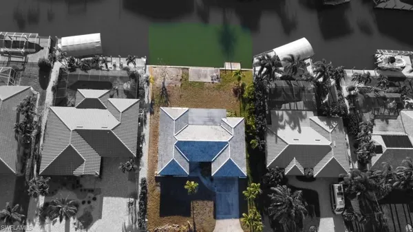 an aerial view of a house with a yard and lake view
