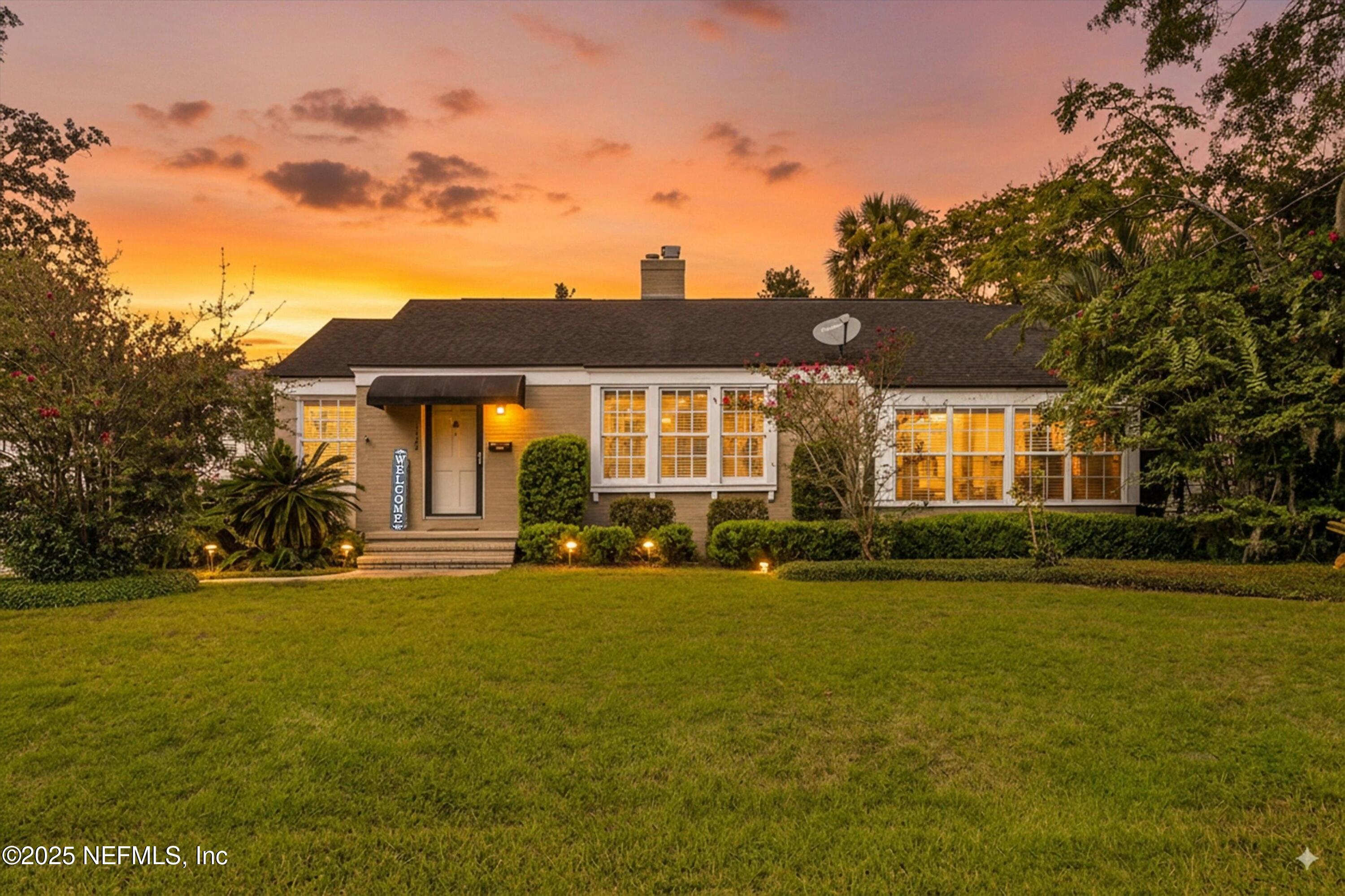 a front view of a building with a garden