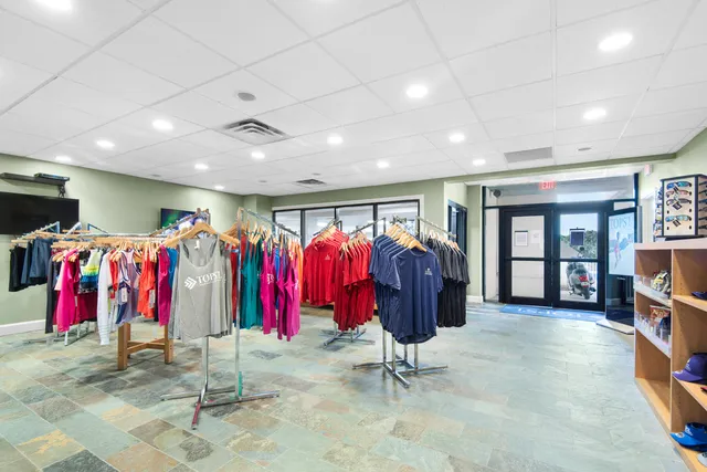 a view of a white house with a big yard and palm trees