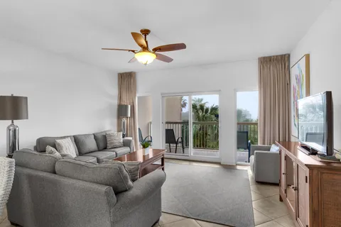 a living room with furniture a ceiling fan and a flat screen tv