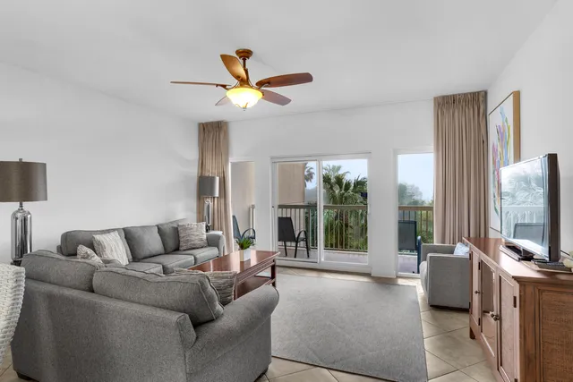 a living room with furniture a ceiling fan and a flat screen tv