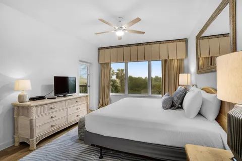 a bedroom with a large bed and a flat tv screen on dresser