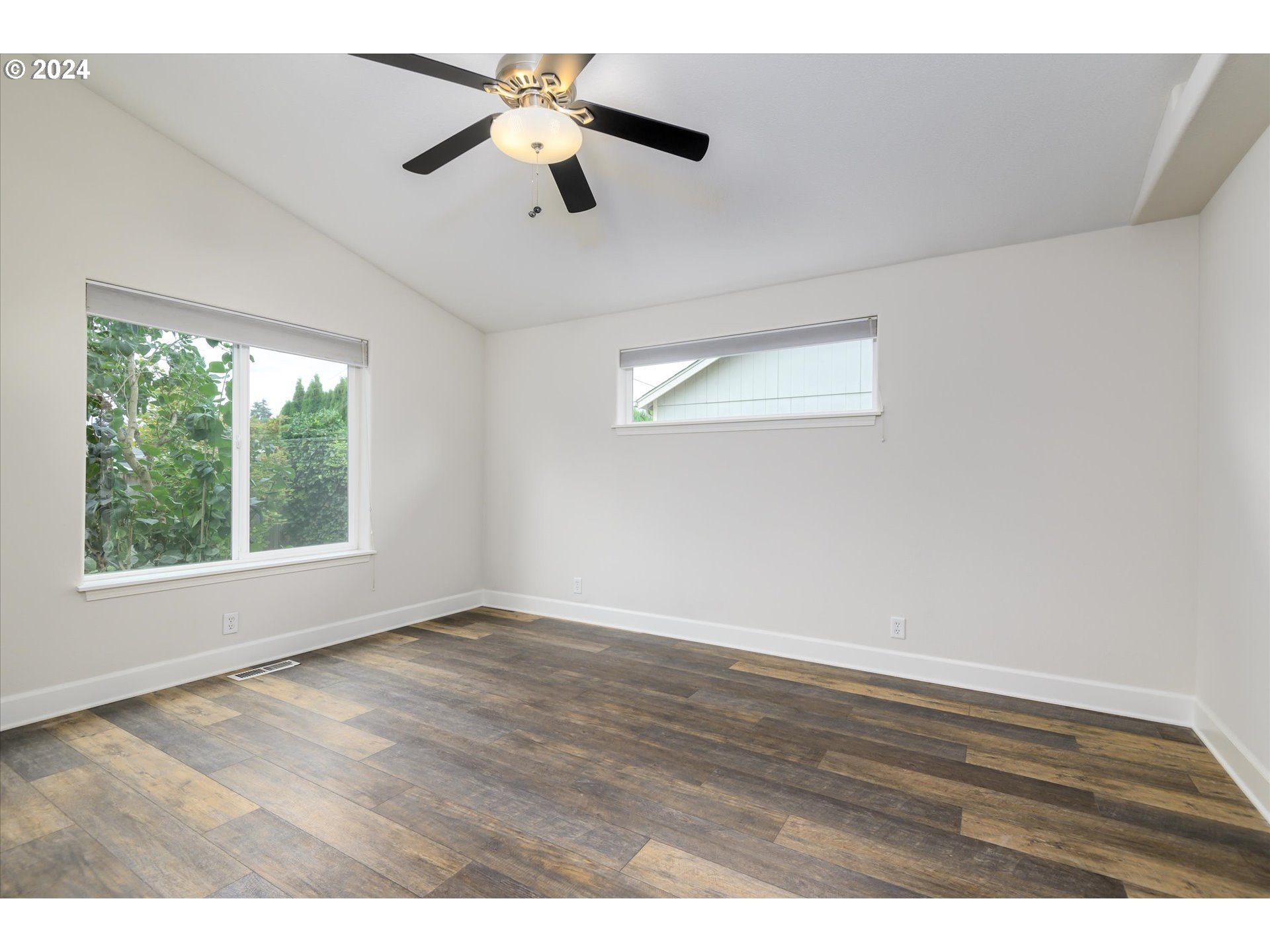 654 62nd Street Springfield, OR 97478 - Photo 18 of 41 an empty room with wooden floor chandelier fan and windows
