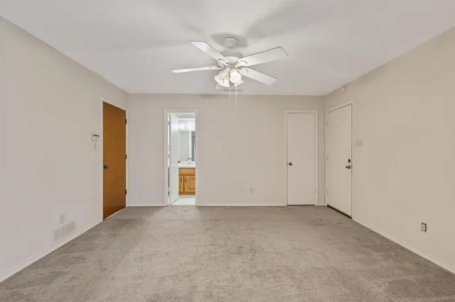 a view of an empty room with a ceiling fan