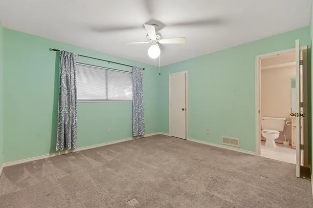 a view of an empty room and chandelier fan