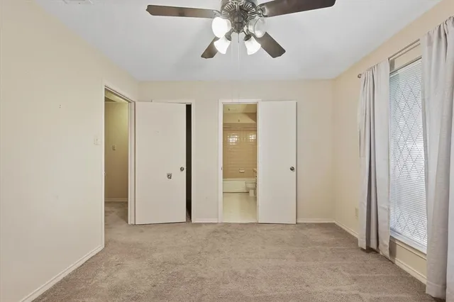 an empty room with fan and windows