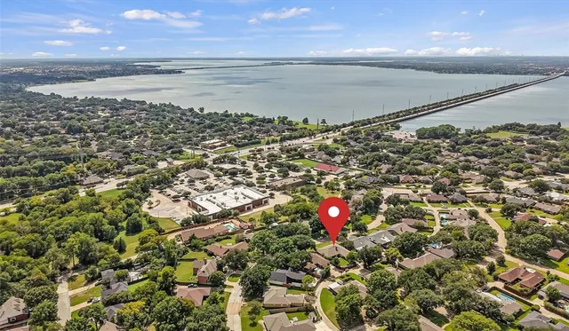 an aerial view of residential house with pool and trees all around