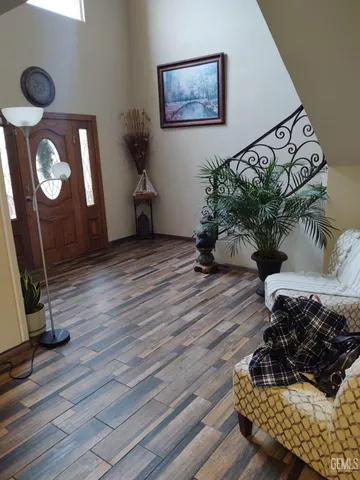 a living room with wooden floor furniture and a potted plant