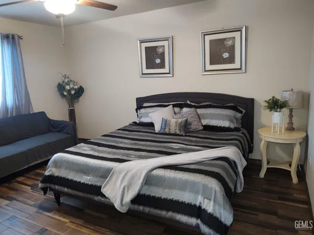 a bedroom with a bed and wooden floor