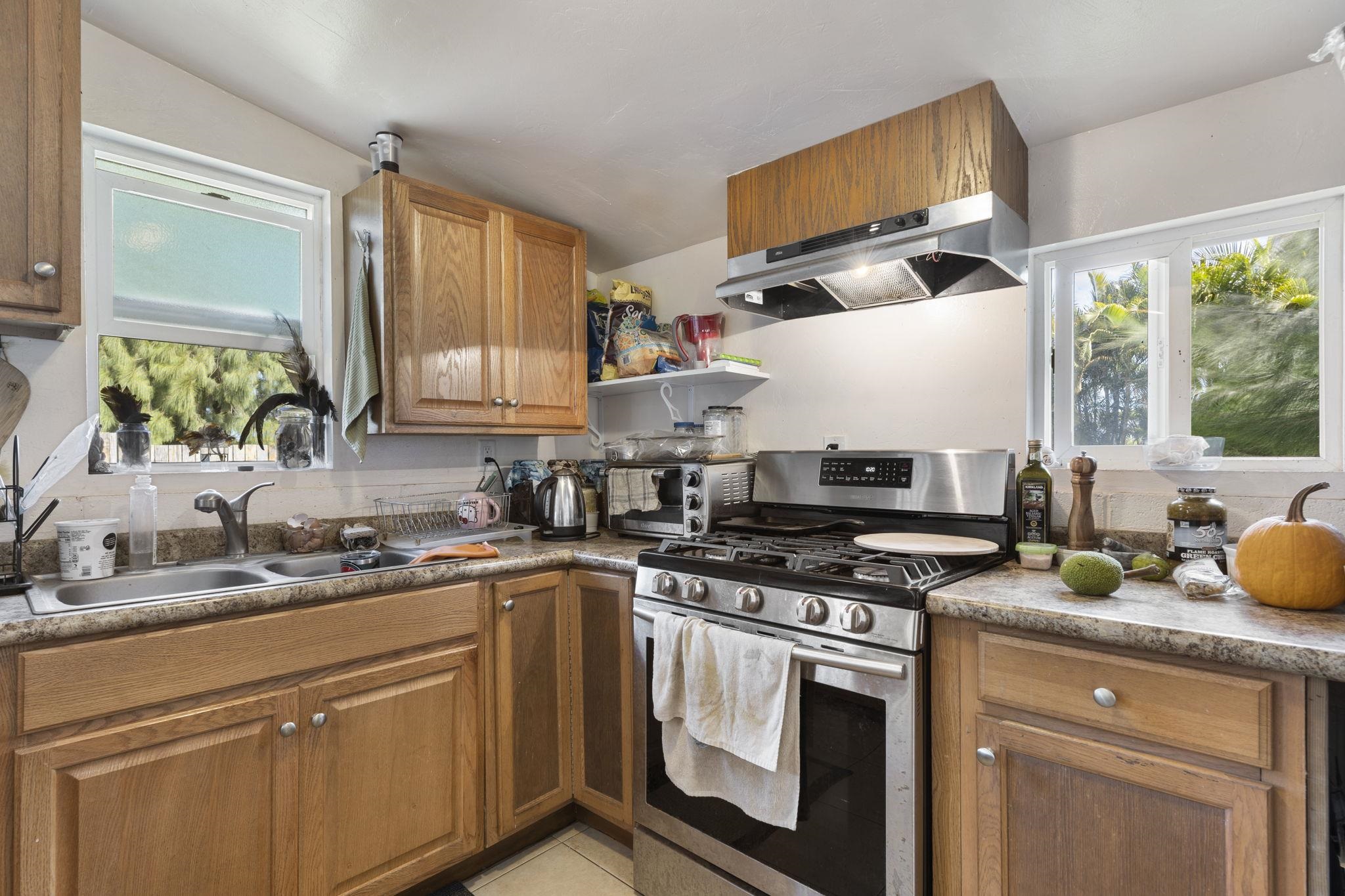 89 Nahele Road Haiku, HI 96708 - Photo 22 of 30 a kitchen with stainless steel appliances a stove a sink and a microwave