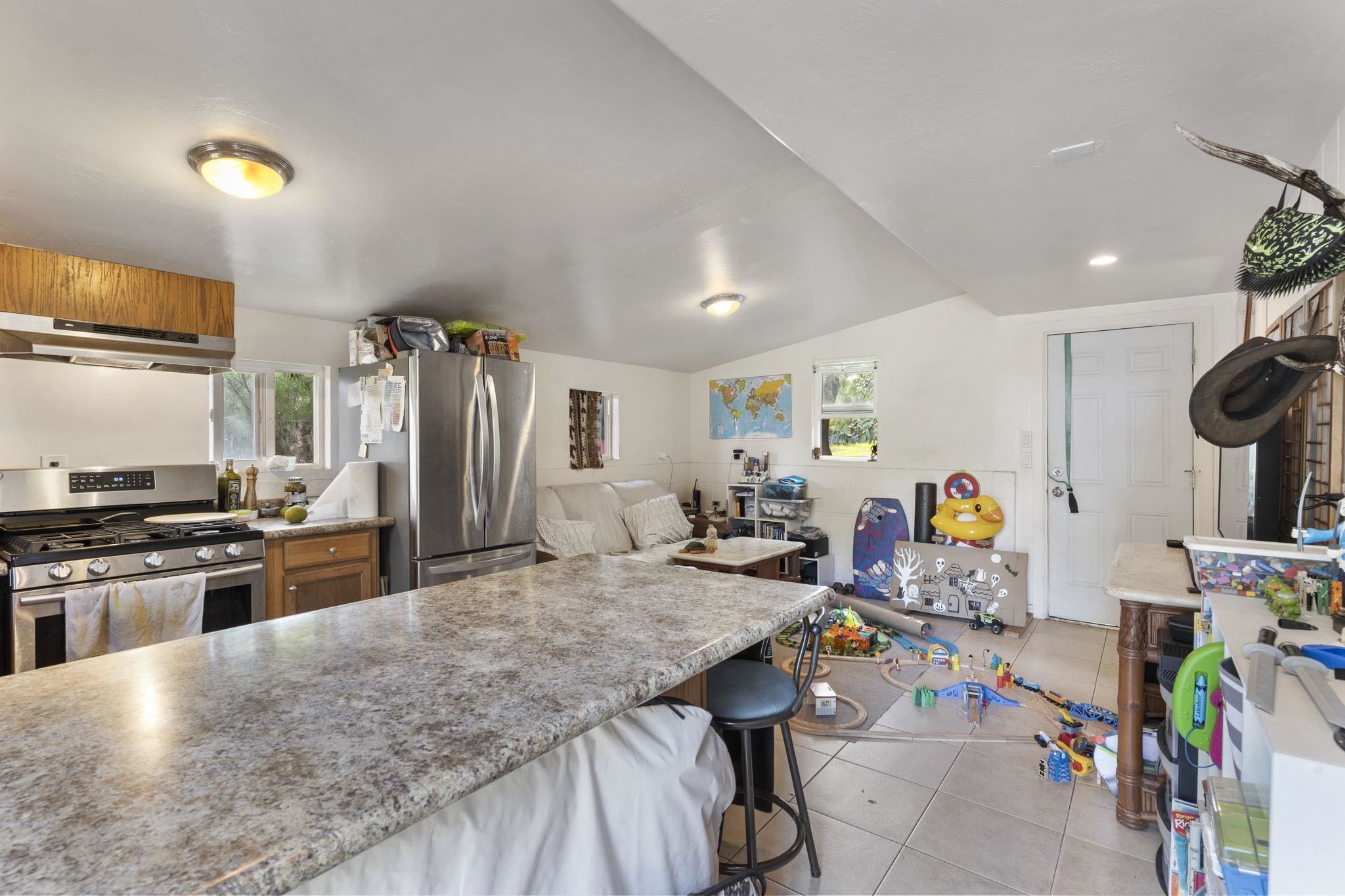 89 Nahele Road Haiku, HI 96708 - Photo 23 of 30 a kitchen with stainless steel appliances granite countertop a sink a stove and a refrigerator