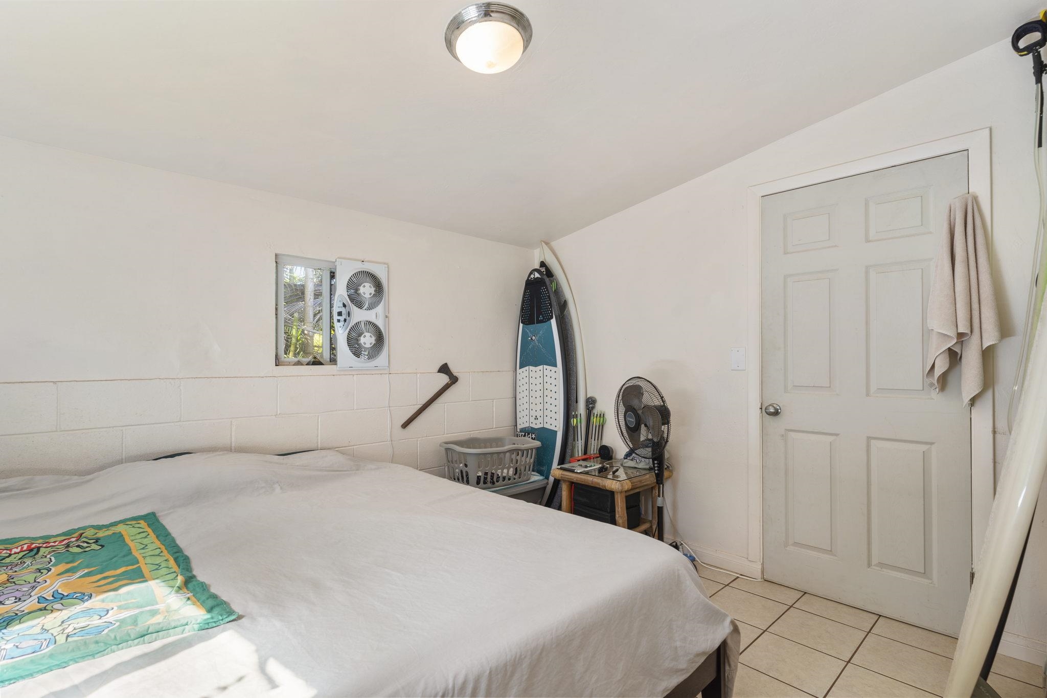 89 Nahele Road Haiku, HI 96708 - Photo 24 of 30 a bedroom with a bed a table and painting on the wall