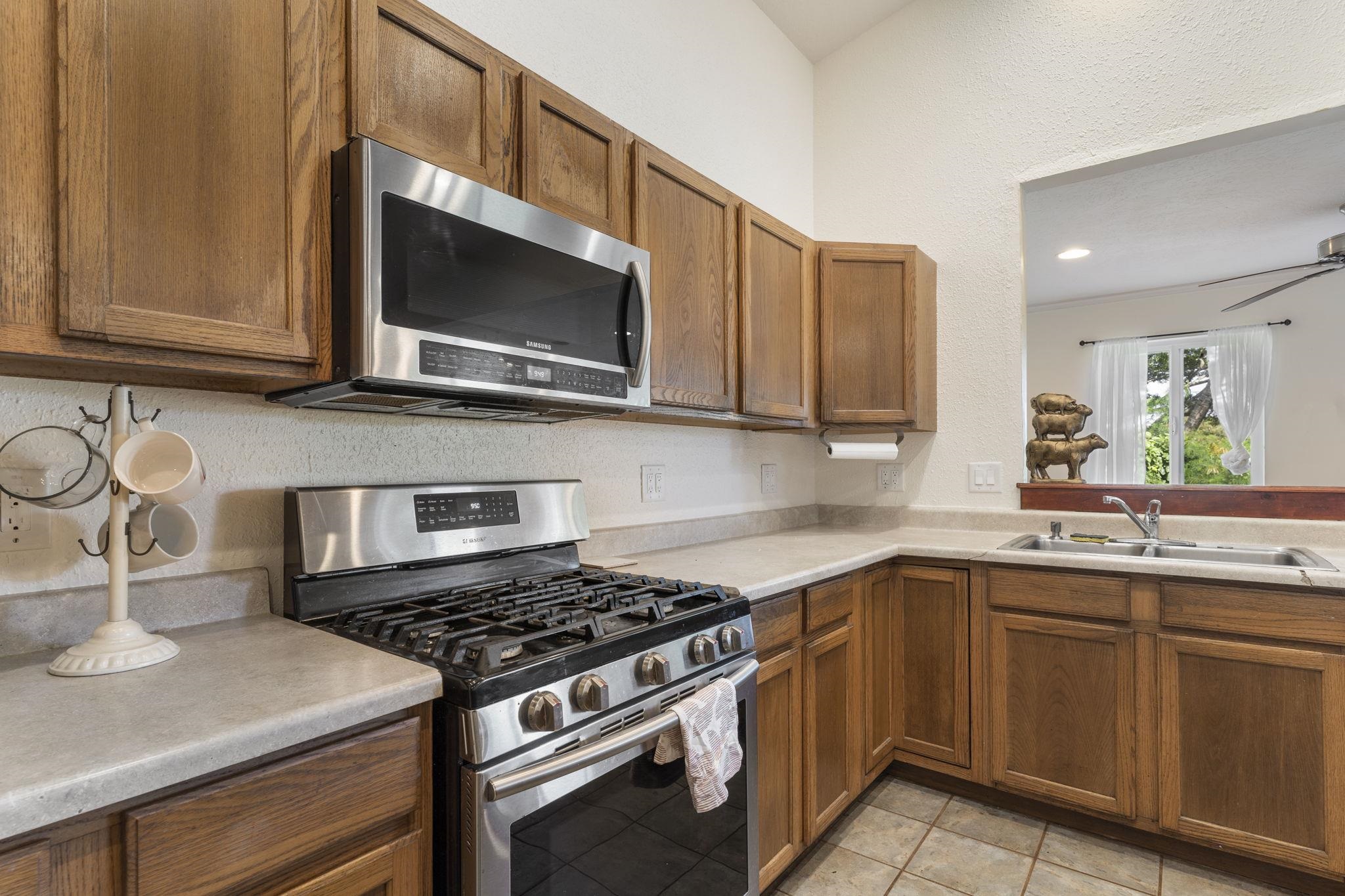 89 Nahele Road Haiku, HI 96708 - Photo 7 of 30 a kitchen with stainless steel appliances a sink dishwasher stove microwave and cabinets