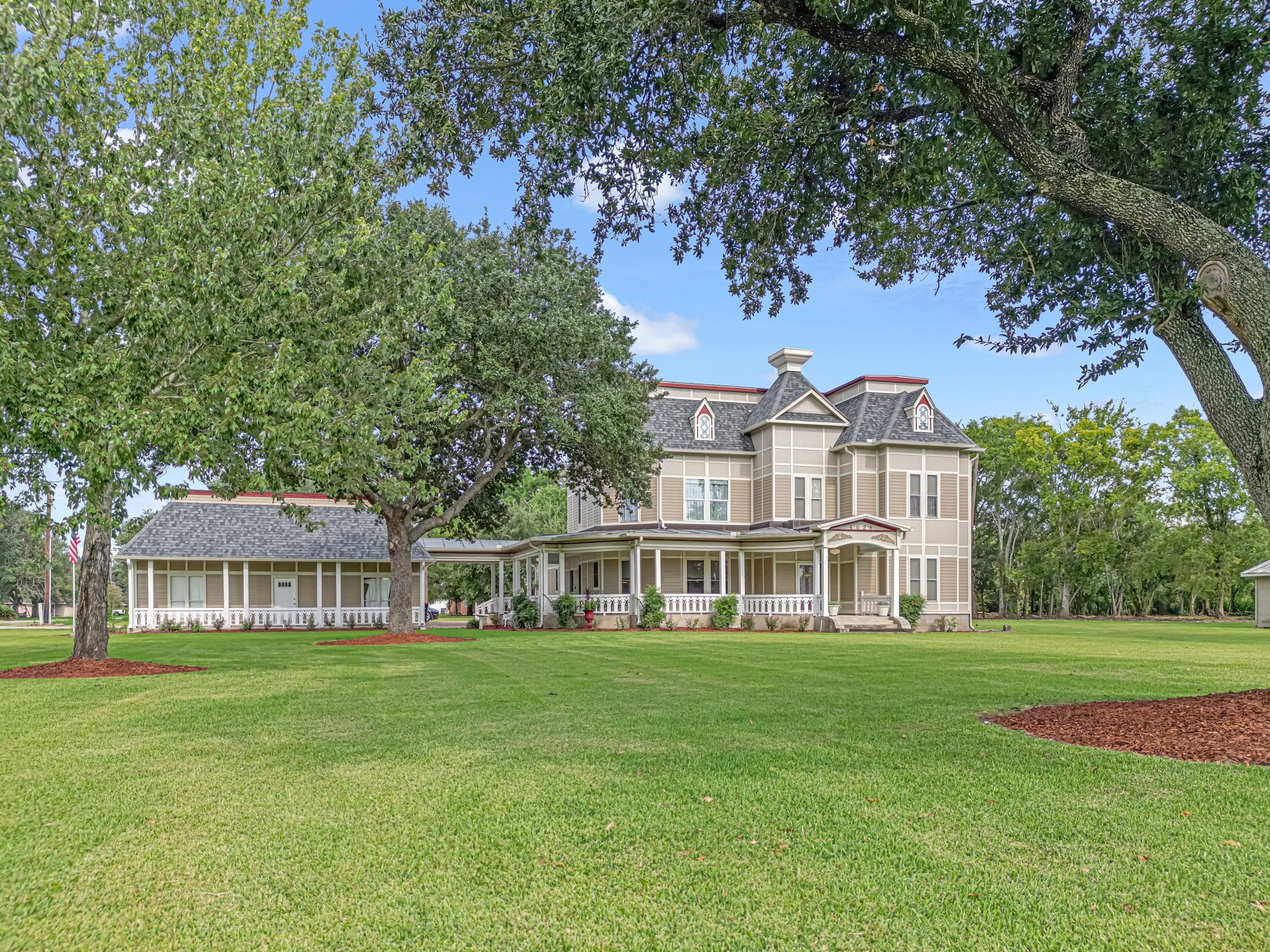 A showstopping Queen Anne–style Victorian set on park-like grounds. The deep wraparound porch, ornate gables and dormers, and an extended side wing create timeless curb appeal and abundant outdoor living. Mature oaks frame the expansive lawn—perfect for gatherings, gardens, or quiet evenings on the veranda.