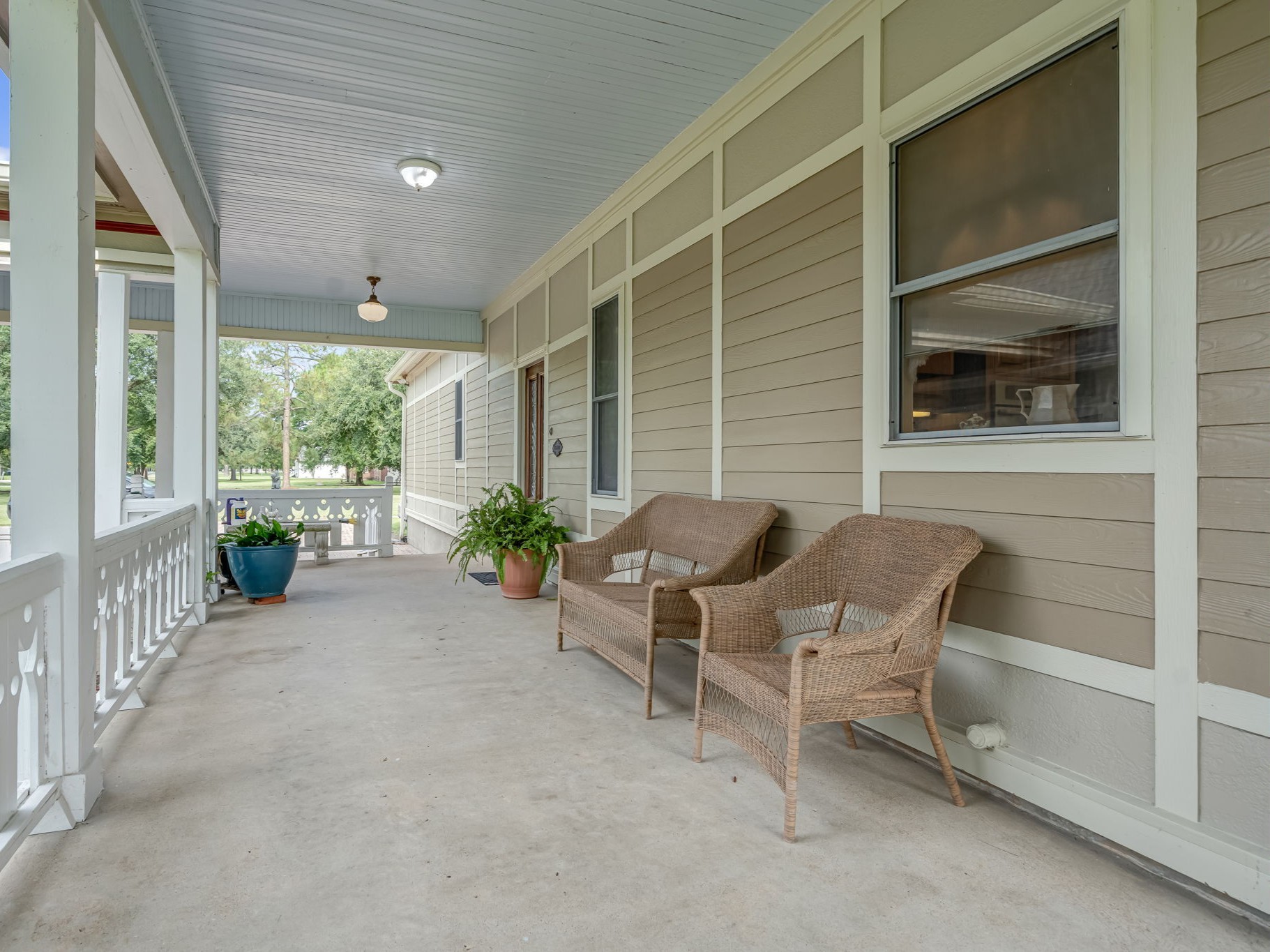 4028 Crosby Cedar Bayou Road Baytown, TX 77521 - Photo 3 of 35 A gracious wraparound veranda frames the home with timeless appeal. Under a beadboard ceiling and along a classic balustrade, multiple seating areas invite quiet mornings and lingering evenings. The porch connects effortlessly to the rear entry, garage, and drive, elevating both everyday convenience and curbside sophistication.