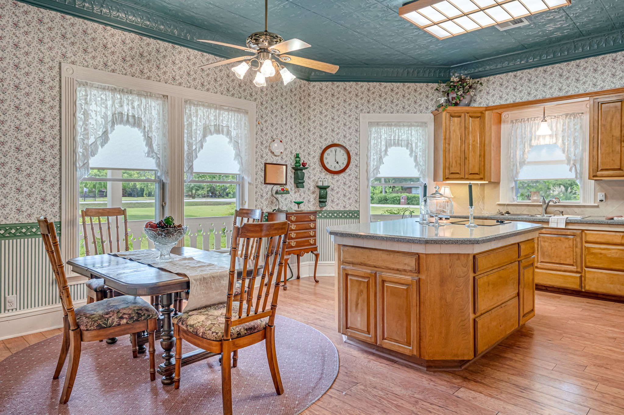 4028 Crosby Cedar Bayou Road Baytown, TX 77521 - Photo 10 of 35 A gracious, light-filled kitchen where everyday living feels special. The painted pressed-tin ceiling adds vintage character above the generous center island and warm wood cabinetry, while broad windows and a convenient exterior door frame lovely views of the wraparound porch and manicured lawn—perfect for morning coffee or easy indoor-outdoor entertaining.