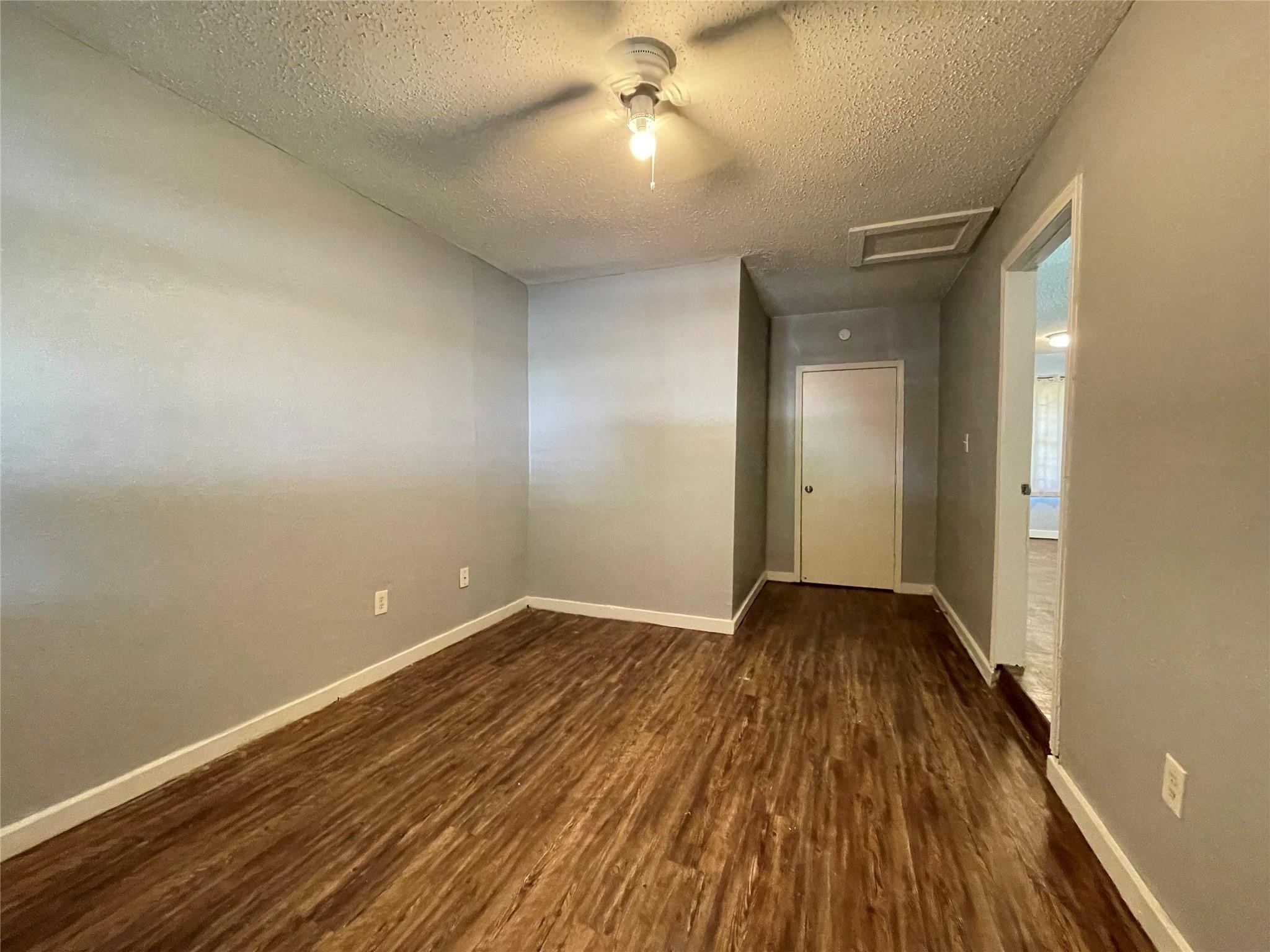 5213 Anzio Road Houston, TX 77033 - Photo 17 of 20 an empty room with wooden floor and windows