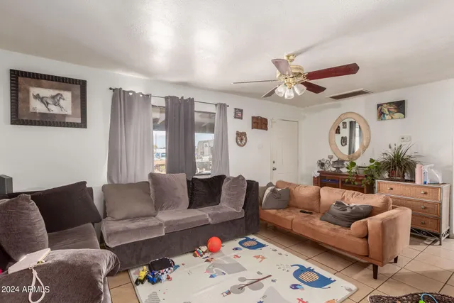 a living room with furniture ceiling fan and a window