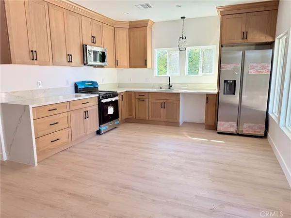 a kitchen with granite countertop a refrigerator and a sink
