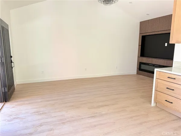 an empty room with wooden floor and cabinet