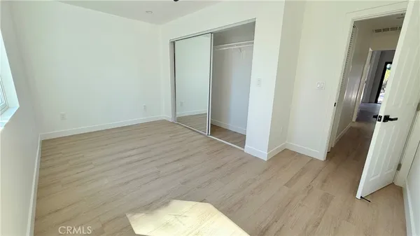 an empty room with wooden floor and glass doors