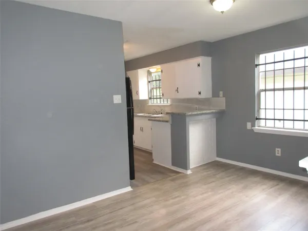 an empty room with window and wooden floor