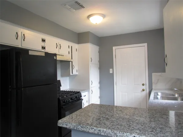 a kitchen with stainless steel appliances granite countertop a refrigerator a stove and a sink