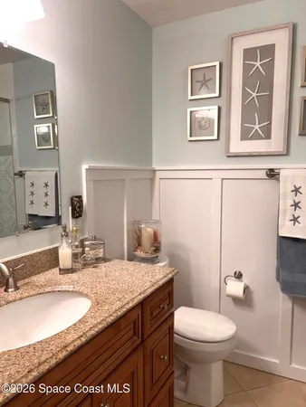 a bathroom with a granite countertop toilet sink and mirror