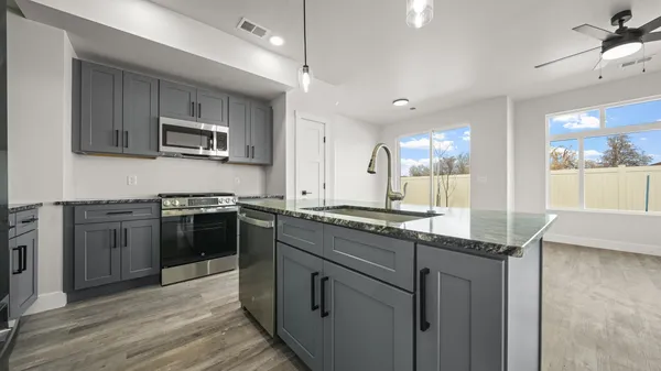 a kitchen with stainless steel appliances granite countertop a stove top oven a sink and dishwasher