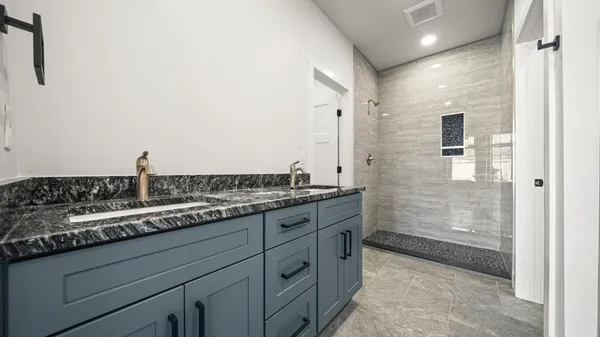 a bathroom with a granite countertop sink and a mirror